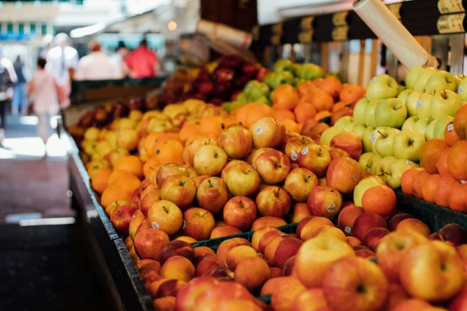 Farmers Market fruit stand with apples and oranges in local town market near River Road Estates luxury homes